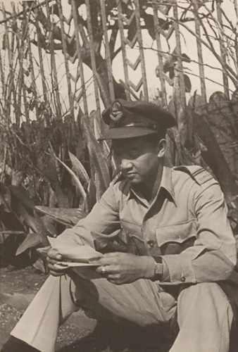 Charlie Chow relaxing in Burma with a letter.